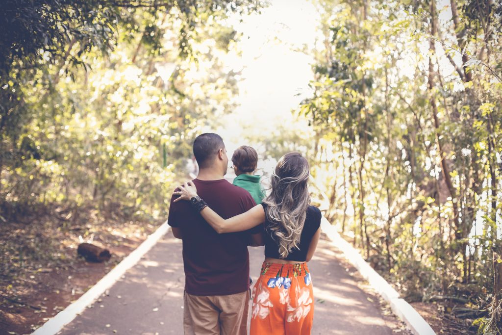 Parents walking together with their young child, reflecting how parenting changes your relationship